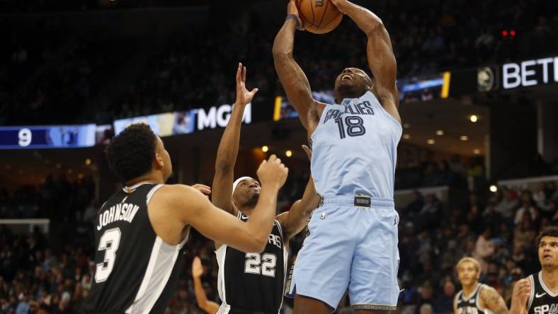 Jan 2, 2024; Memphis, Tennessee, USA; Memphis Grizzlies center Bismack Biyombo (18) collects a rebound over San Antonio Spurs guard Malaki Branham (22) during the first half at FedExForum. Mandatory Credit: Petre Thomas-USA TODAY Sports