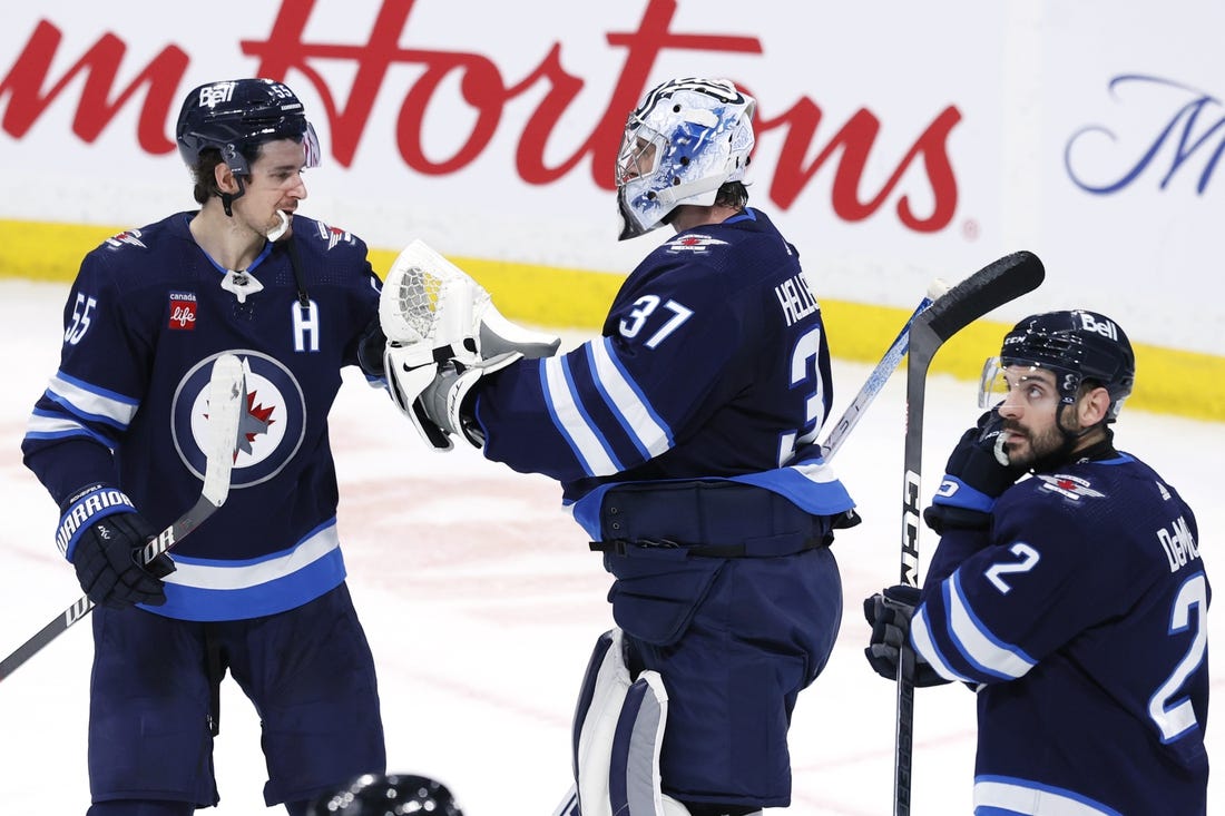 Jan 2, 2024; Winnipeg, Manitoba, CAN; Winnipeg Jets center Mark Scheifele (55) and Winnipeg Jets goaltender Connor Hellebuyck (37) celebrate their victory over the Tampa Bay Lightning at Canada Life Centre. Mandatory Credit: James Carey Lauder-USA TODAY Sports