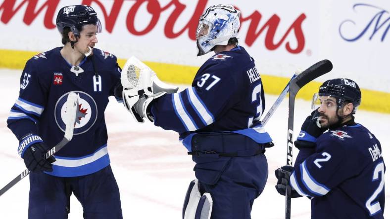 Jan 2, 2024; Winnipeg, Manitoba, CAN; Winnipeg Jets center Mark Scheifele (55) and Winnipeg Jets goaltender Connor Hellebuyck (37) celebrate their victory over the Tampa Bay Lightning at Canada Life Centre. Mandatory Credit: James Carey Lauder-USA TODAY Sports