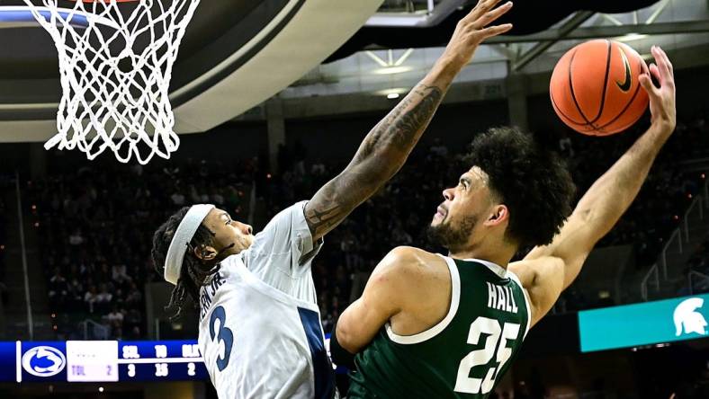 Jan 4, 2024; East Lansing, Michigan, USA; Michigan State Spartans forward Malik Hall (25) slams the ball home against Penn State Nittany Lions guard Nick Kern Jr. (3) during the second half at Jack Breslin Student Events Center. Mandatory Credit: Dale Young-USA TODAY Sports