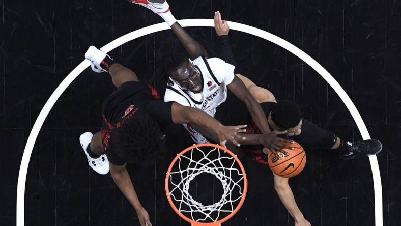 Jan 6, 2024; San Diego, California, USA; San Diego State Aztecs forward Jay Pal (center) goes to the basket defended by UNLV Rebels forward Rob Whaley Jr. (5) and guard Justin Webster (right) during the first half at Viejas Arena. Mandatory Credit: Orlando Ramirez-USA TODAY Sports