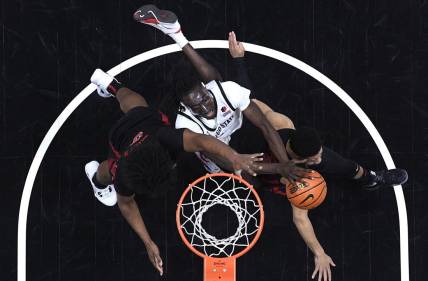 Jan 6, 2024; San Diego, California, USA; San Diego State Aztecs forward Jay Pal (center) goes to the basket defended by UNLV Rebels forward Rob Whaley Jr. (5) and guard Justin Webster (right) during the first half at Viejas Arena. Mandatory Credit: Orlando Ramirez-USA TODAY Sports