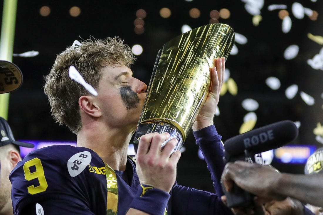 Michigan quarterback J.J. McCarthy kisses the championship trophy to celebrate the Wolverines' 34-13 win over Washington in the national championship game at NRG Stadium in Houston on Monday, Jan. 8, 2024.