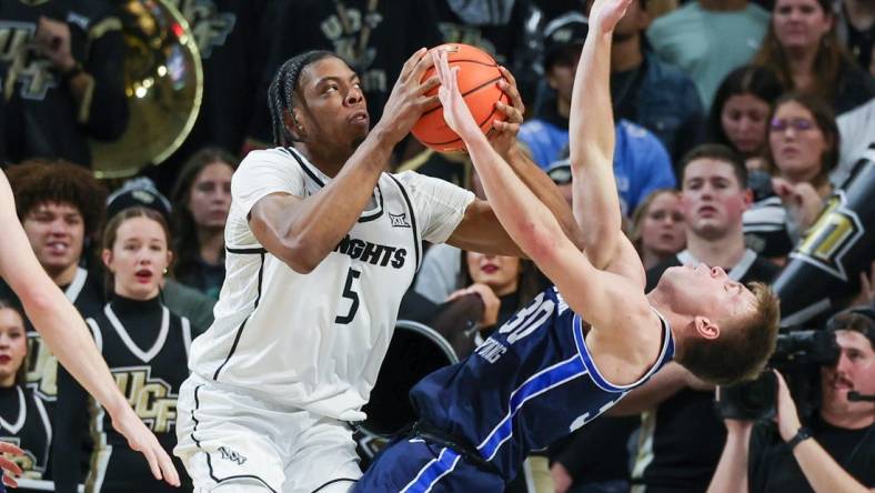 Jan 13, 2024; Orlando, Florida, USA; Brigham Young Cougars guard Dallin Hall (30) is fouled by UCF Knights forward Omar Payne (5) during the first period at Addition Financial Arena. Mandatory Credit: Mike Watters-USA TODAY Sports