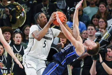 Jan 13, 2024; Orlando, Florida, USA; Brigham Young Cougars guard Dallin Hall (30) is fouled by UCF Knights forward Omar Payne (5) during the first period at Addition Financial Arena. Mandatory Credit: Mike Watters-USA TODAY Sports