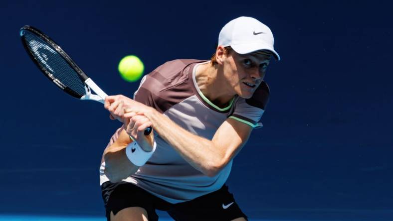 Jan 14, 2024; Melbourne, Victoria, Australia;   Jannik Sinner of Italy hits a shot against Botic Van De Zandschulp of the Netherlands in the first round of the men s singles. Mandatory Credit: Mike Frey-USA TODAY Sports