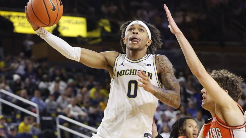 Jan 18, 2024; Ann Arbor, Michigan, USA;  Michigan Wolverines guard Dug McDaniel (0) shoots on Illinois Fighting Illini guard Niccolo Moretti (11) in the first half at Crisler Center. Mandatory Credit: Rick Osentoski-USA TODAY Sports