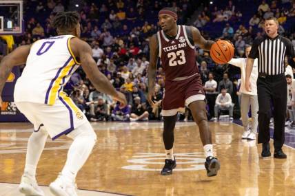 Jan 20, 2024; Baton Rouge, Louisiana, USA;  Texas A&M Aggies guard Tyrece Radford (23) dribbles against LSU Tigers guard Trae Hannibal (0) during the second half at Pete Maravich Assembly Center. Mandatory Credit: Stephen Lew-USA TODAY Sports