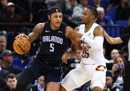 Jan 22, 2024; Orlando, Florida, USA; Cleveland Cavaliers forward Isaac Okoro (35) defends Orlando Magic forward Paolo Banchero (5) during the second quarter at Kia Center. Mandatory Credit: Kim Klement Neitzel-USA TODAY Sports