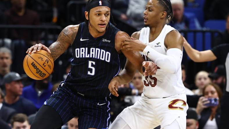 Jan 22, 2024; Orlando, Florida, USA; Cleveland Cavaliers forward Isaac Okoro (35) defends Orlando Magic forward Paolo Banchero (5) during the second quarter at Kia Center. Mandatory Credit: Kim Klement Neitzel-USA TODAY Sports