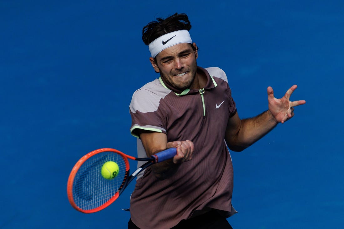 Jan 23, 2024; Melbourne, Victoria, Australia;  
Taylor Fritz of the United States in action against Novak Djokovic of Serbia in the quarter final of the men s singles. Mandatory Credit: Mike Frey-USA TODAY Sports