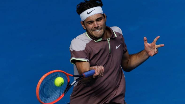 Jan 23, 2024; Melbourne, Victoria, Australia;  
Taylor Fritz of the United States in action against Novak Djokovic of Serbia in the quarter final of the men s singles. Mandatory Credit: Mike Frey-USA TODAY Sports