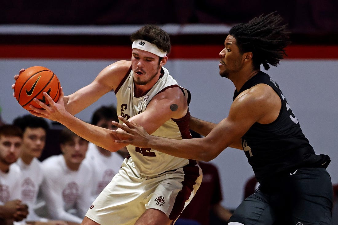 Jan 23, 2024; Blacksburg, Virginia, USA; Boston College Eagles forward Quinten Post (12) handles the ball against Virginia Tech Hokies forward Mylyjael Poteat (34) during the second half at Cassell Coliseum. Mandatory Credit: Peter Casey-USA TODAY Sports