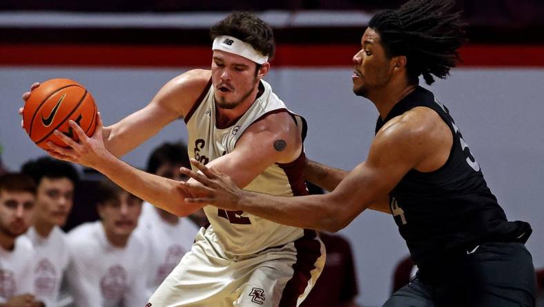 Jan 23, 2024; Blacksburg, Virginia, USA; Boston College Eagles forward Quinten Post (12) handles the ball against Virginia Tech Hokies forward Mylyjael Poteat (34) during the second half at Cassell Coliseum. Mandatory Credit: Peter Casey-USA TODAY Sports