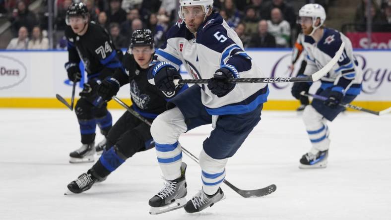 Jan 24, 2024; Toronto, Ontario, CAN; Winnipeg Jets defenseman Brenden Dillon (5) chases after a loose puck against the Toronto Maple Leafs during the third period at Scotiabank Arena. Mandatory Credit: John E. Sokolowski-USA TODAY Sports