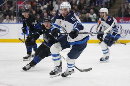 Jan 24, 2024; Toronto, Ontario, CAN; Winnipeg Jets defenseman Brenden Dillon (5) chases after a loose puck against the Toronto Maple Leafs during the third period at Scotiabank Arena. Mandatory Credit: John E. Sokolowski-USA TODAY Sports