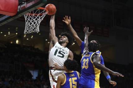 Jan 27, 2024; Coral Gables, Florida, USA; Miami Hurricanes forward Norchad Omier (15) dunks the basketball against Pittsburgh Panthers guard Jaland Lowe (15), center Federiko Federiko (33) and forward Zack Austin (55) during the second half at Watsco Center. Mandatory Credit: Sam Navarro-USA TODAY Sports