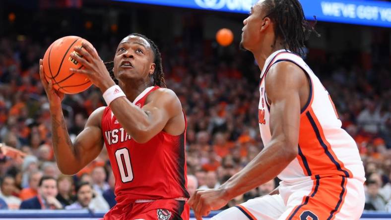 Jan 27, 2024; Syracuse, New York, USA; North Carolina State Wolfpack guard DJ Horne (0) drives as Syracuse Orange guard JJ Starling (2) defends during the first half at the JMA Wireless Dome. Mandatory Credit: Rich Barnes-USA TODAY Sports