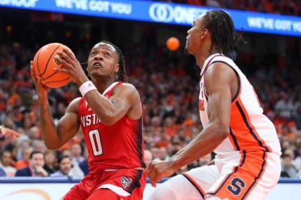 Jan 27, 2024; Syracuse, New York, USA; North Carolina State Wolfpack guard DJ Horne (0) drives as Syracuse Orange guard JJ Starling (2) defends during the first half at the JMA Wireless Dome. Mandatory Credit: Rich Barnes-USA TODAY Sports