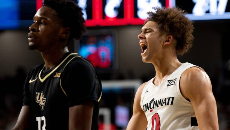 Cincinnati Bearcats guard Dan Skillings Jr. (0) reacts to hitting a 3-point basket over UCF Knights forward Marchelus Avery (13) to put Cincinnati Bearcats up by 5 points with under 3 minutes to play in the second half of the NCAA basketball game between Cincinnati Bearcats and UCF Knights at Fifth Third Arena in Cincinnati on Saturday, Jan. 27, 2024.