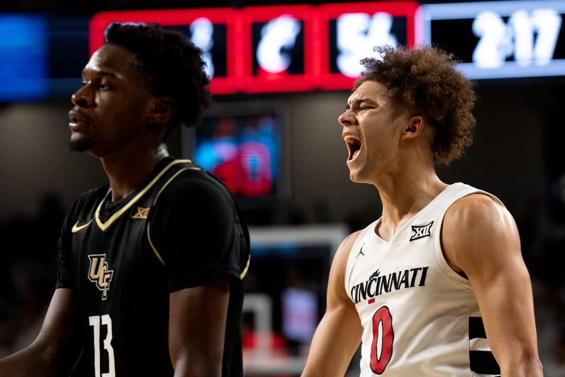 Cincinnati Bearcats guard Dan Skillings Jr. (0) reacts to hitting a 3-point basket over UCF Knights forward Marchelus Avery (13) to put Cincinnati Bearcats up by 5 points with under 3 minutes to play in the second half of the NCAA basketball game between Cincinnati Bearcats and UCF Knights at Fifth Third Arena in Cincinnati on Saturday, Jan. 27, 2024.
