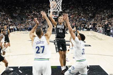 Jan 27, 2024; San Antonio, Texas, USA; San Antonio Spurs forward Jeremy Sochan (10) drives to the basket past Minnesota Timberwolves centers Rudy Gobert (27) and Karl-Anthony Towns (32) during the second half at Frost Bank Center. Mandatory Credit: Scott Wachter-USA TODAY Sports