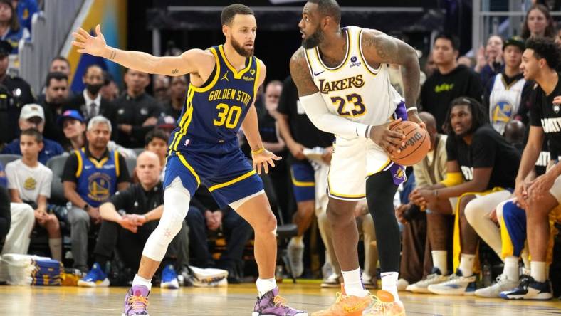 Jan 27, 2024; San Francisco, California, USA; Golden State Warriors guard Stephen Curry (30) defends against Los Angeles Lakers forward LeBron James (23) during overtime at Chase Center. Mandatory Credit: Darren Yamashita-USA TODAY Sports