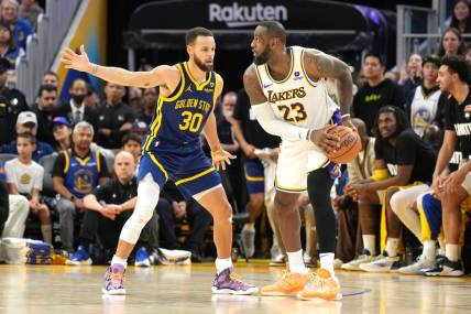 Jan 27, 2024; San Francisco, California, USA; Golden State Warriors guard Stephen Curry (30) defends against Los Angeles Lakers forward LeBron James (23) during overtime at Chase Center. Mandatory Credit: Darren Yamashita-USA TODAY Sports