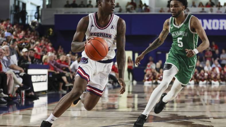 Jan 28, 2024; Boca Raton, Florida, USA; Florida Atlantic Owls guard Johnell Davis (1) drives to the basket past North Texas Mean Green guard Rondel Walker (5) during the second half at Eleanor R. Baldwin Arena. Mandatory Credit: Sam Navarro-USA TODAY Sports