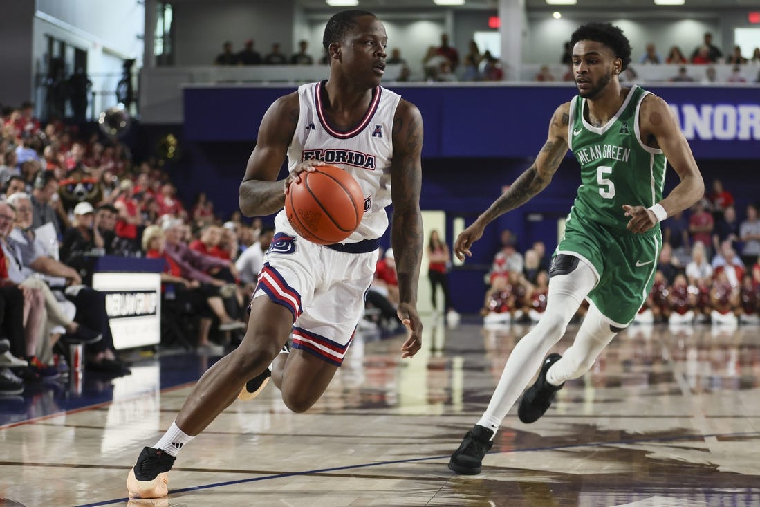 Jan 28, 2024; Boca Raton, Florida, USA; Florida Atlantic Owls guard Johnell Davis (1) drives to the basket past North Texas Mean Green guard Rondel Walker (5) during the second half at Eleanor R. Baldwin Arena. Mandatory Credit: Sam Navarro-USA TODAY Sports