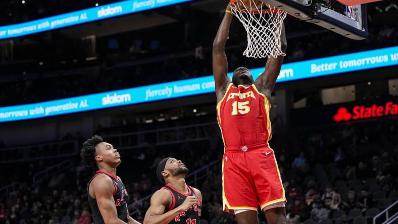 Jan 28, 2024; Atlanta, Georgia, USA; Atlanta Hawks center Clint Capela (15) dunks behind Toronto Raptors forwards Scottie Barnes (4) and Bruce Brown (11) during the first half at State Farm Arena. Mandatory Credit: Dale Zanine-USA TODAY Sports