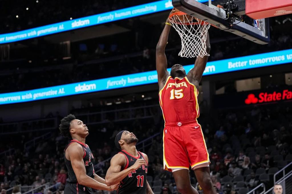 Jan 28, 2024; Atlanta, Georgia, USA; Atlanta Hawks center Clint Capela (15) dunks behind Toronto Raptors forwards Scottie Barnes (4) and Bruce Brown (11) during the first half at State Farm Arena. Mandatory Credit: Dale Zanine-USA TODAY Sports