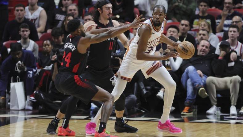 Jan 29, 2024; Miami, Florida, USA; Phoenix Suns forward Kevin Durant (35) protects the basketball from Miami Heat forward Haywood Highsmith (24) and guard Jaime Jaquez Jr. (11) during the third quarter at Kaseya Center. Mandatory Credit: Sam Navarro-USA TODAY Sports