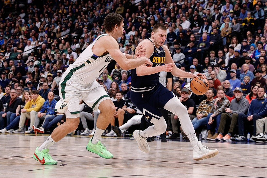 Jan 29, 2024; Denver, Colorado, USA; Denver Nuggets center Nikola Jokic (15) controls the ball against Milwaukee Bucks center Brook Lopez (11) in the fourth quarter at Ball Arena. Mandatory Credit: Isaiah J. Downing-USA TODAY Sports