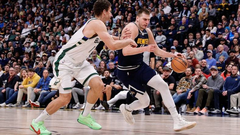 Jan 29, 2024; Denver, Colorado, USA; Denver Nuggets center Nikola Jokic (15) controls the ball against Milwaukee Bucks center Brook Lopez (11) in the fourth quarter at Ball Arena. Mandatory Credit: Isaiah J. Downing-USA TODAY Sports