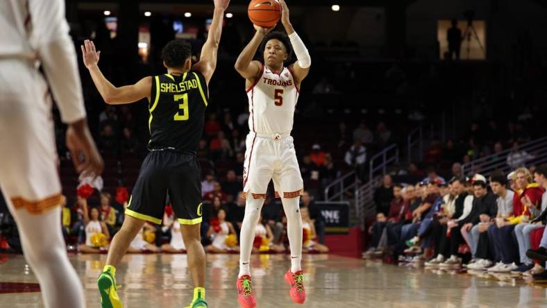 Feb 1, 2024; Los Angeles, California, USA; USC Trojans guard Boogie Ellis (5) shoots the ball over Oregon Ducks guard Jackson Shelstad (3) during the first half at Galen Center. Mandatory Credit: Kiyoshi Mio-USA TODAY Sports