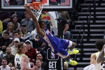 Feb 1, 2024; Salt Lake City, Utah, USA; Philadelphia 76ers guard Tyrese Maxey (0) hangs on the rim after a dunk against the Utah Jazz during the fourth quarter at Delta Center. Mandatory Credit: Rob Gray-USA TODAY Sports