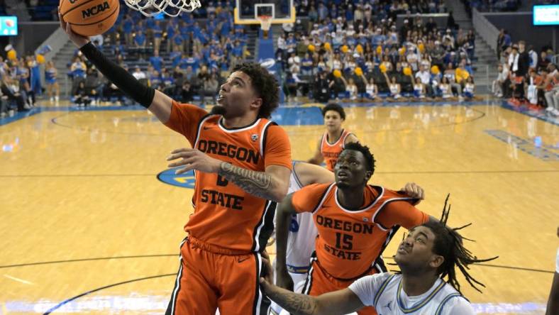 Feb 1, 2024; Los Angeles, California, USA; Oregon State Beavers guard Jordan Pope (0) scores past UCLA Bruins guard Brandon Williams (5) in the first half at Pauley Pavilion presented by Wescom. Mandatory Credit: Jayne Kamin-Oncea-USA TODAY Sports