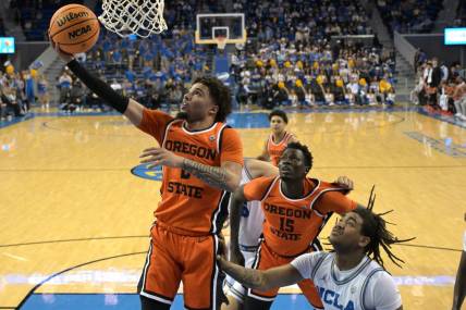 Feb 1, 2024; Los Angeles, California, USA; Oregon State Beavers guard Jordan Pope (0) scores past UCLA Bruins guard Brandon Williams (5) in the first half at Pauley Pavilion presented by Wescom. Mandatory Credit: Jayne Kamin-Oncea-USA TODAY Sports
