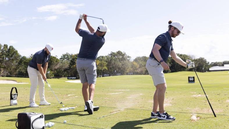 Feb 2, 2024; Playa del Carmen, Quintana Roo, MEX; Jon Rahm of Team Legion XIII, center, hits on the practice range with teammates Tyrrell Hatton, left, and Kieran Vincent before the first round of the LIV Golf Mayakoba tournament at El Chamaleon Golf Course. Mandatory Credit: Erich Schlegel-USA TODAY Sports