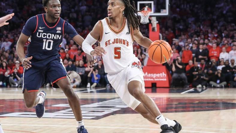 Feb 3, 2024; New York, New York, USA;  St. John's Red Storm guard Daniss Jenkins (5) drives past Connecticut Huskies guard Hassan Diarra (10) in the second half at Madison Square Garden. Mandatory Credit: Wendell Cruz-USA TODAY Sports