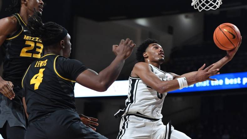 Feb 3, 2024; Nashville, Tennessee, USA; Vanderbilt Commodores guard Tyrin Lawrence (0) scores past Missouri Tigers forward Aidan Shaw (23) and guard Curt Lewis (4) during the first half at Memorial Gymnasium. Mandatory Credit: Christopher Hanewinckel-USA TODAY Sports