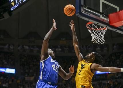 Feb 3, 2024; Morgantown, West Virginia, USA; Brigham Young Cougars forward Fousseyni Traore (45) shoots over West Virginia Mountaineers guard Kobe Johnson (2) during the first half at WVU Coliseum. Mandatory Credit: Ben Queen-USA TODAY Sports
