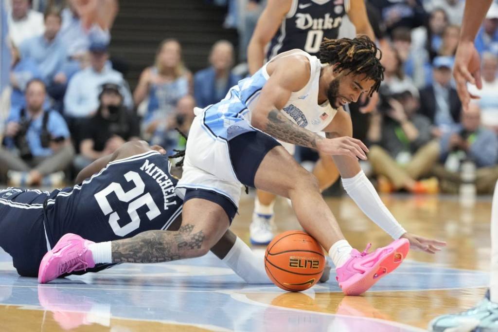 Feb 3, 2024; Chapel Hill, North Carolina, USA;  Duke Blue Devils forward Mark Mitchell (25) and North Carolina Tar Heels guard RJ Davis (4) fight for the ball in the first half at Dean E. Smith Center. Mandatory Credit: Bob Donnan-USA TODAY Sports