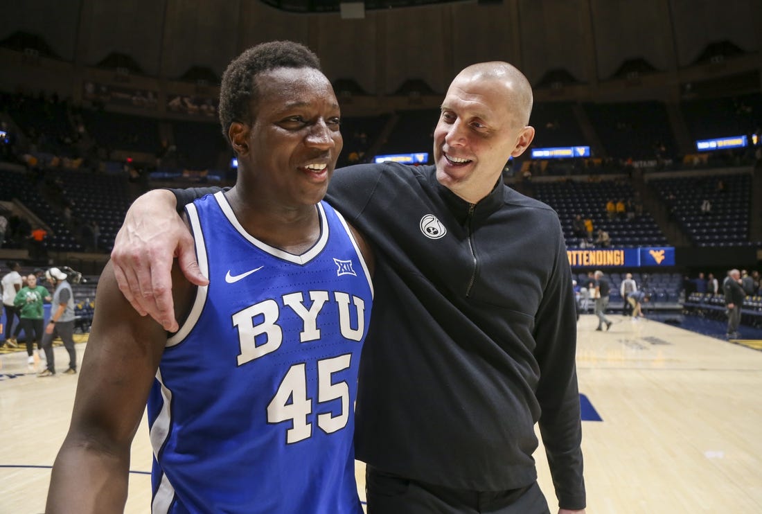 Feb 3, 2024; Morgantown, West Virginia, USA; Brigham Young Cougars head coach Mark Pope celebrates with Brigham Young Cougars forward Fousseyni Traore (45) after defeating the West Virginia Mountaineers at WVU Coliseum. Mandatory Credit: Ben Queen-USA TODAY Sports