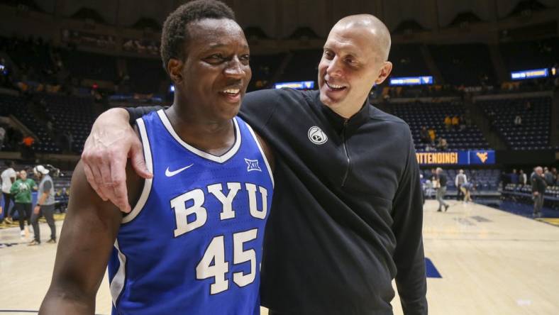 Feb 3, 2024; Morgantown, West Virginia, USA; Brigham Young Cougars head coach Mark Pope celebrates with Brigham Young Cougars forward Fousseyni Traore (45) after defeating the West Virginia Mountaineers at WVU Coliseum. Mandatory Credit: Ben Queen-USA TODAY Sports