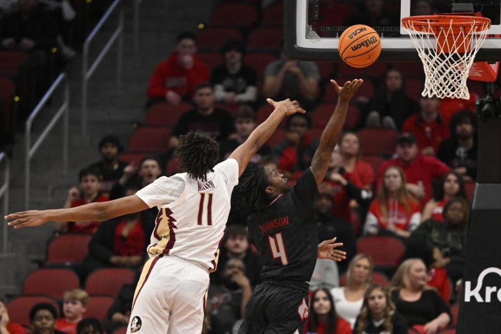 Feb 3, 2024; Louisville, Kentucky, USA; Louisville Cardinals guard Ty-Laur Johnson (4) shoots against Florida State Seminoles forward Baba Miller (11) during the first half at KFC Yum! Center. Mandatory Credit: Jamie Rhodes-USA TODAY Sports