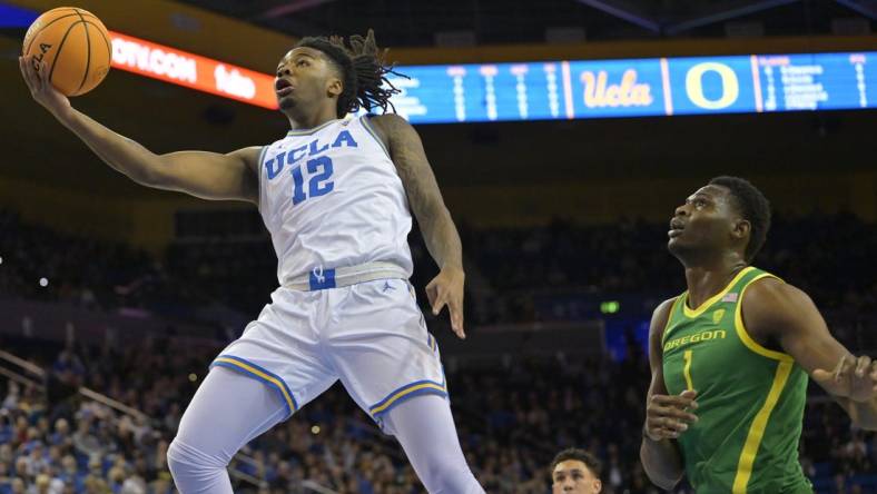 Feb 3, 2024; Los Angeles, California, USA; UCLA Bruins guard Sebastian Mack (12) drives past Oregon Ducks center N'Faly Dante (1) for a basket in the first half at Pauley Pavilion presented by Wescom. Mandatory Credit: Jayne Kamin-Oncea-USA TODAY Sports