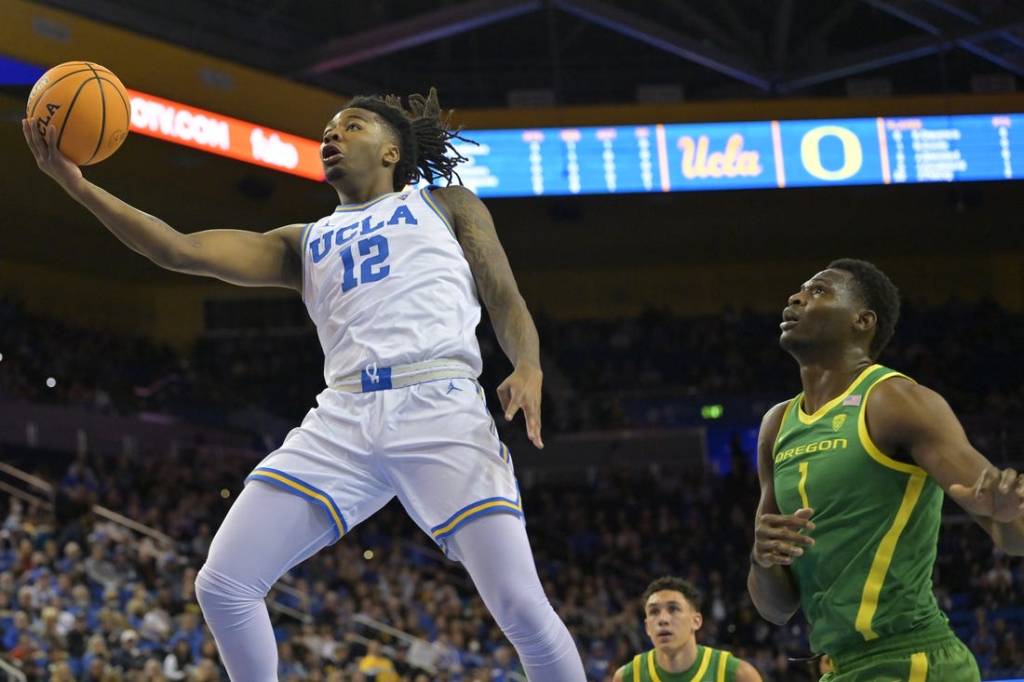 Feb 3, 2024; Los Angeles, California, USA; UCLA Bruins guard Sebastian Mack (12) drives past Oregon Ducks center N'Faly Dante (1) for a basket in the first half at Pauley Pavilion presented by Wescom. Mandatory Credit: Jayne Kamin-Oncea-USA TODAY Sports