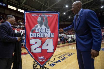 Detroit Mercy athletic director Robert C. Vowels, Jr., left, and Earl Cureton, unveil the No. 24 jersey retirement during the ceremony at Calihan Hall in Detroit, Thursday, Jan. 23, 2020.